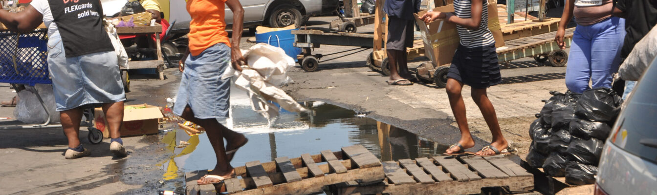 Shoppers trying to cross a pool of raw sewage on Heywood street in downtown Kingston on Saturday April 18, 2015.