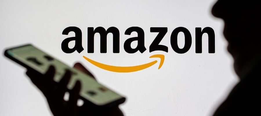 FILE PHOTO: Woman with smartphone is seen in front of displayed Amazon logo in this illustration taken